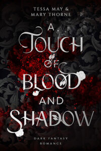 Cover von A Touch of Blood and Shadow von Tessa May und Mary Thorne: Ein schwarzer Hintergrund mit Ornamenten, mittig Blutstropfen, darüber in weiß der Buchtitel. 