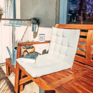 Martinas Lese- und Sonnenplatz. Eine Balkonbank mit Kissen, Buch und Tasse, Gemütlichkeit pur